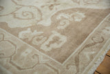 Distressed texture of ivory germinating tendrils on a pale coffee brown Oushak rug.