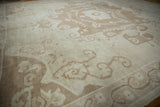 Distressed vintage Oushak rug detail: ivory field with beige scrolling germinating tendrils.