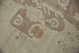 Vintage distressed Oushak rug detail showing worn pile texture and coffee brown scrolling tendrils on ivory.