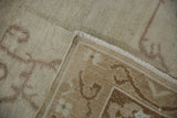 Vintage distressed Oushak rug corner, revealing reverse weave, fringe, and processing tag.