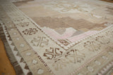 Vintage Distressed Oushak rug corner with pale geometric motifs and subtle abrashes.
