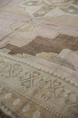 Soft geometric motifs and varied neutral shades on a vintage distressed Oushak rug pile.