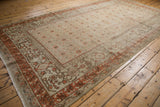 Distressed Khotan carpet corner, faded terracotta border and worn texture field.