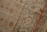 Distressed vintage Khotan carpet showcasing burnt orange floral lattice and heirloom texture.