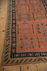 Navy blue crab border and geometric tree of life motif on a tomato red Khotan runner.