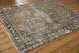 Distressed vintage Dargezine carpet: navy meandering vine border, dusty rose field, visible foundation.
