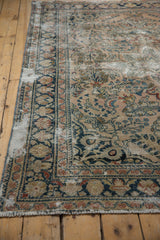 Distressed Dargezine carpet corner showing worn navy, cherry red floral border, exposed foundation.