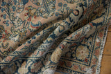 Distressed vintage Dargezine carpet with navy vine border and rosy field.