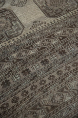 Textured pile of a distressed vintage Ersari rug showing muted charcoal gul motifs.