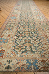 Antique Malayer runner's geometric border featuring checkered cross-sections and germinating plant motifs.