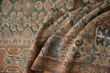 Close-up of antique Malayer runner's textured pile, wide geometric border, and plant motif.
