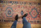 Vintage distressed Karaja runner: abrashed blush field, geometric blue medallion, evident wear.