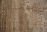 Close-up of vintage Oushak pile showcasing sand and beige abrash and geometric contours.