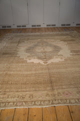 Vintage distressed Oushak carpet's light fringe, abrashed field, and blush pomegranate border.