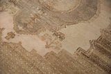 Distressed Oushak rug with a stepped medallion outline and textured abrashed sand field.