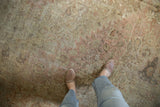 Distressed Sivas rug texture with worn pile, visible foundation, dusty rose and ivory.