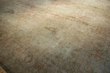 Textured distressed Sivas carpet with muted floral patterns in dusty rose, ivory, and silver.