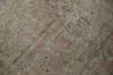 Distressed Sivas carpet showing faded dusty rose and antique ivory floral motifs.