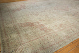 Distressed Sivas carpet corner with faded dusty rose floral motif and low pile.
