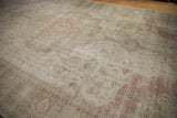 Visible wear and distressed texture with faded ivory and dusty rose patterns.
