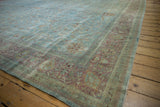 Corner of distressed Meshed carpet with faded powder blue, blush red, and vinery pattern.