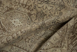 Folded vintage Karaja rug showing distressed pile, silver, ivory, and charcoal geometric palmette motifs.