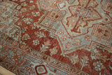 Distressed vintage Heriz carpet with even wear, featuring chestnut red and dusty blue geometric motifs.