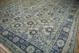 Corner detail of distressed Oushak carpet, with cobalt blue floral border and ivory field.