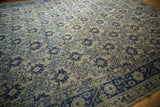 Distressed Oushak carpet's cobalt blue main border with floral motifs and ivory field.