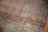 Distressed Kerman carpet's worn texture, faded raspberry blush, and powder blue millefleur design.