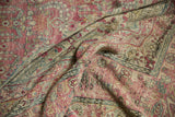 Distressed Kerman carpet's muted raspberry blush, beige, and powder blue millefleur motifs.