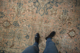 Distressed vintage Tabriz carpet, faded floral patterns in dusty blush and navy.