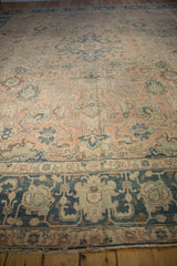 Distressed Persian Tabriz carpet detail: dusty blush field, worn navy floral palmettes, and border.