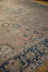 Detailed view of distressed vintage Tabriz rug with blush, navy, and beige floral palmettes.