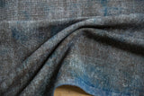 Distressed texture of vintage Sparta carpet, with silver, oxidized silver, and dusty cobalt blue.