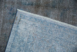 Hand-knotted foundation weave revealed beneath distressed cobalt blue and silver pile.
