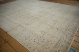Kayseri carpet corner, distressed ivory and beige pile, faint floral and palmette patterns.