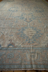 Visible worn pile texture of distressed vintage Oushak rug with pale blue and beige floral motifs.