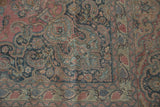 Distressed vintage Khorossan carpet corner with faded red field and Safavid dragon border.