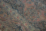 Distressed Khorossan rug detail with faded pink field, blue arabesques, and dragon style border.