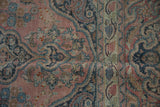 Distressed vintage Khorossan carpet, faded pink field with intricate floral arabesques and visible pile wear.