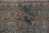 Distressed Khorossan carpet corner with faded blue, red, and beige Safavid dragon and floral motifs.