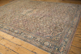 Vintage distressed Hamadan rug corner, displaying faded Herati pattern and border.