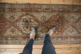 Distressed vintage Serab runner with geometric motifs and subtle chestnut tones.
