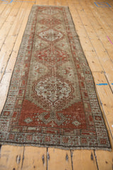 Distressed vintage Serab runner end showing geometric border and ram's horn motif.
