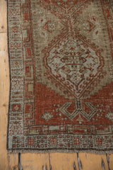 Aged texture, fringed end, and geometric patterns of a distressed vintage Serab runner.