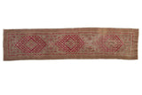 Distressed vintage Khotan runner, cochineal red triple diamond medallions and vine borders.