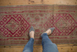 Distressed Khotan runner, cochineal red and beige diamond medallion with lattice designs.