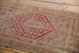 Distressed vintage Khotan rug texture, showing raspberry red lattice and beige plant motifs.