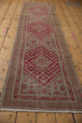Cochineal red germinating plant border and intact selvage on distressed Khotan runner.